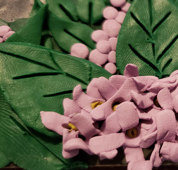 Plasticine illustration of lilacs with green leaves